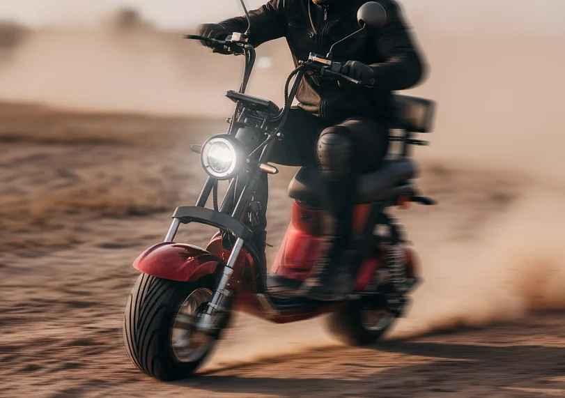 Scooter elétrica X12 em movimento numa estrada de terra